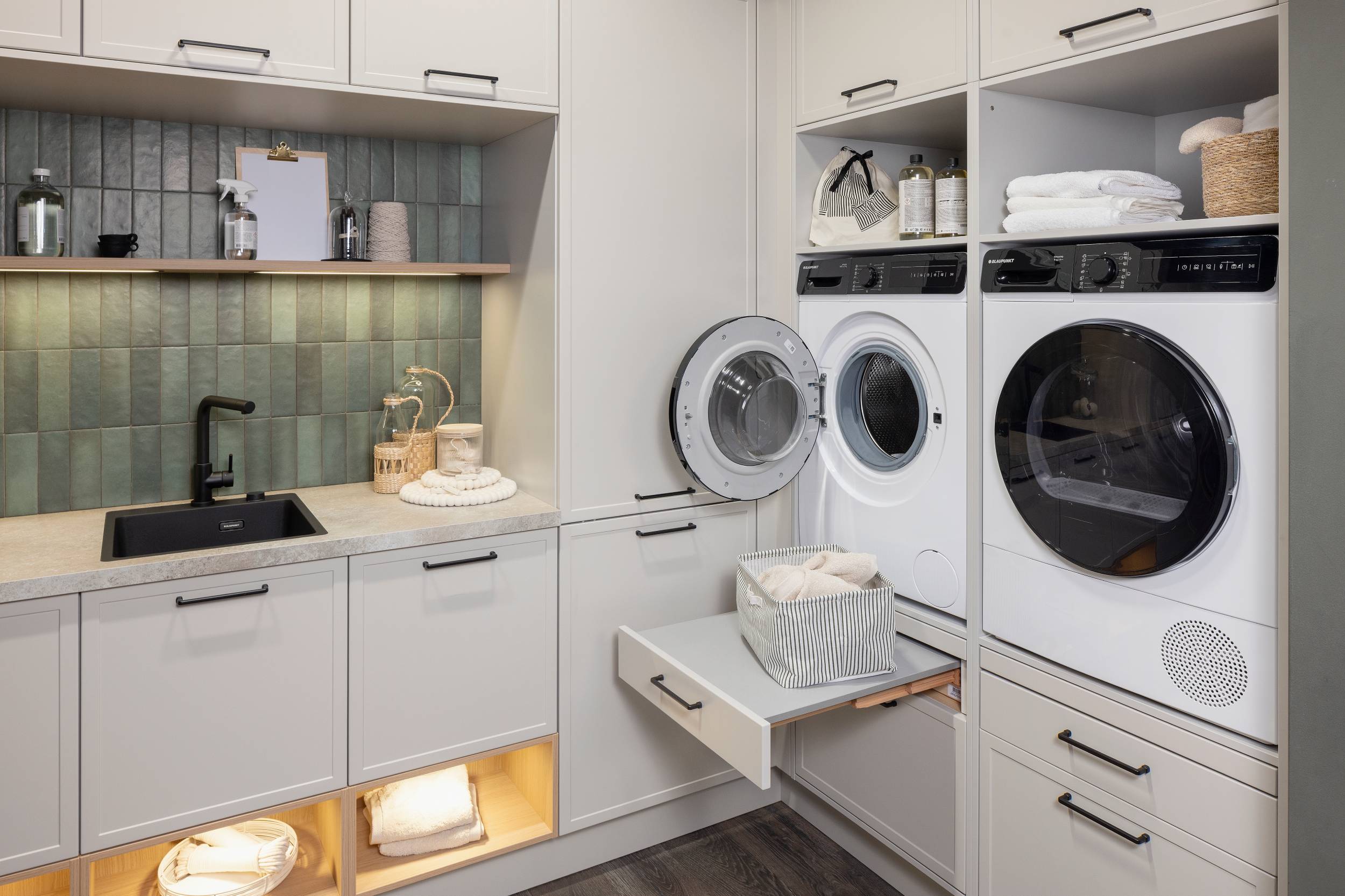 HÄCKER Systemat Hauswirtschaftsraum Lichtgrau Kalkstein - Detailansicht ergonomisch verbaute Waschmaschine und Trockner